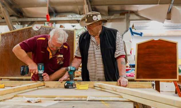 Brett Hooper and Neville Rennie working on display boards for a local sporting group.